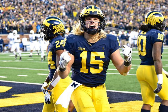 Lavert Hill (24), Chase Winovich (15), and Devin Bush (10)