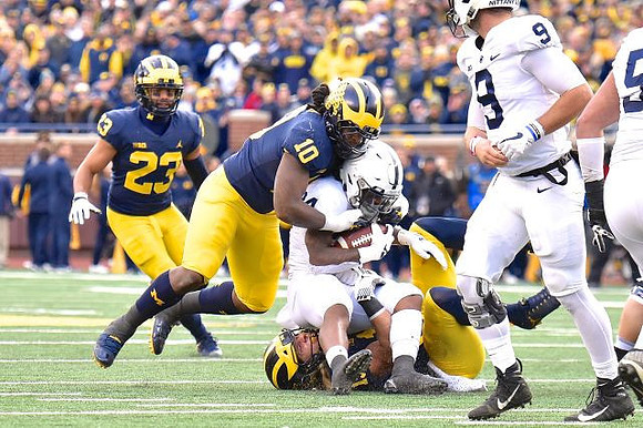 Tyree Kinnel (23), Devin Bush (10), and Chase Winovich (15)