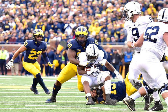 Tyree Kinnel (23), Devin Bush (10), and Chase Winovich (15)