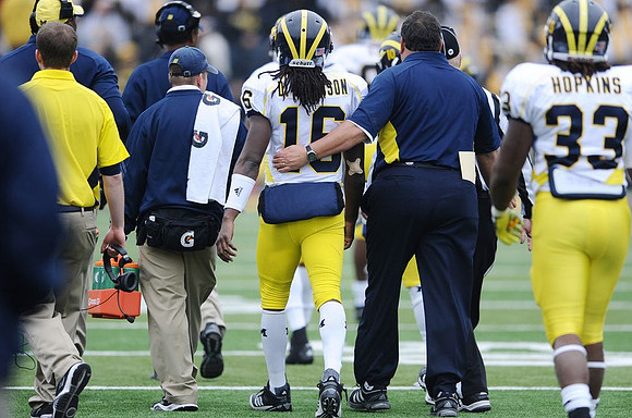 Denard Robinson (16), Brady Hoke, Jeremy Gallon (10), and Stephen Hopkins (33)