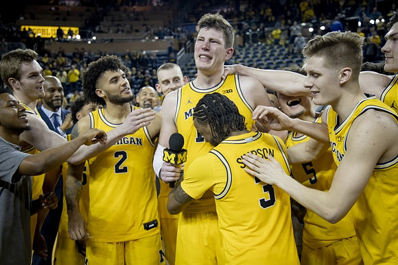 Jon Teske (15), Zavier Simpson (3), and Michigan Team