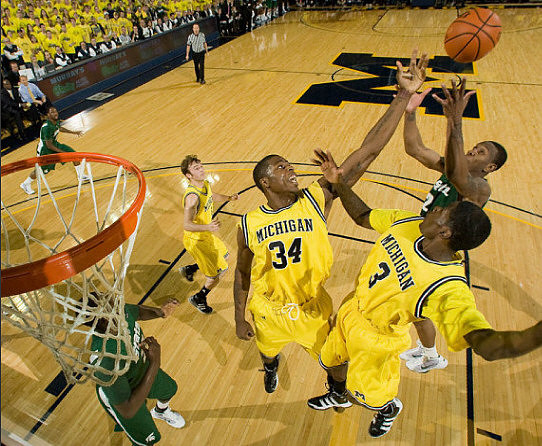 Zack Novak (0), DeShawn Sims (34), and Manny Harris (3)