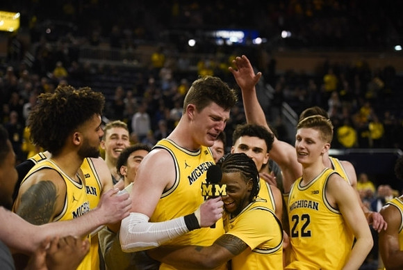 Jon Teske (15), Zavier Simpson (3), and Michigan Team