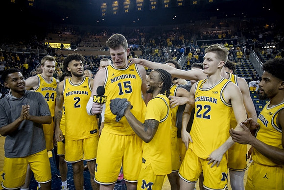 Jon Teske (15), Zavier Simpson (3), and Michigan Team