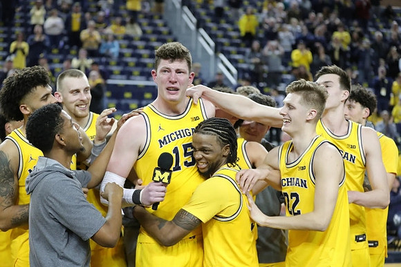 Jon Teske (15), Zavier Simpson (3), and Michigan Team