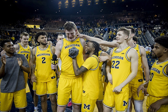 Jon Teske (15), Zavier Simpson (3), and Michigan Team