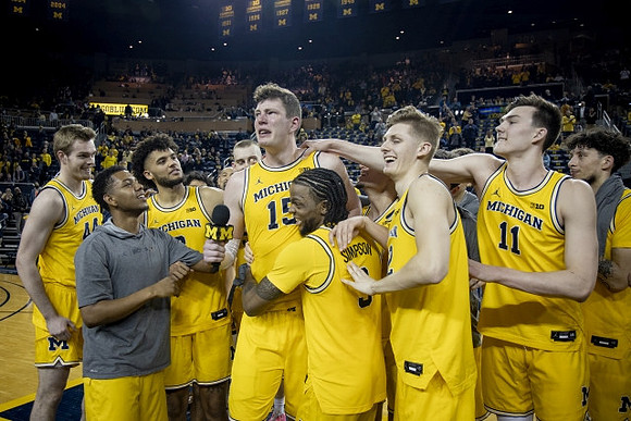 Jon Teske (15), Zavier Simpson (3), and Michigan Team