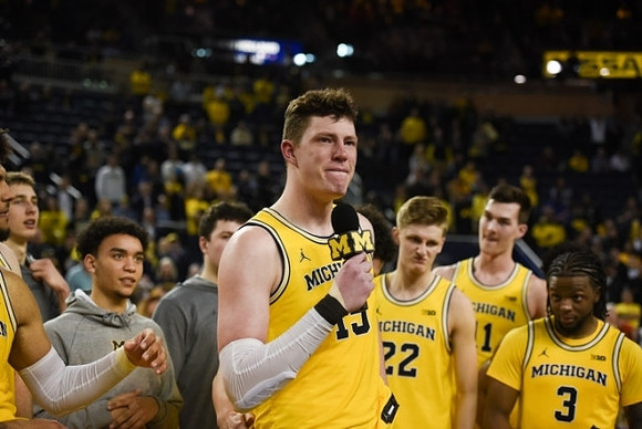 Jon Teske (15), Zavier Simpson (3), and Michigan Team