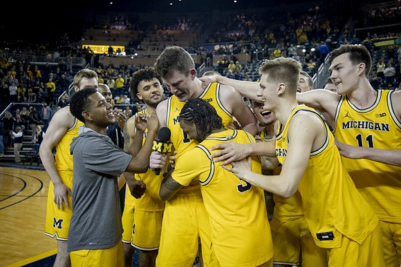 Jon Teske (15), Zavier Simpson (3), and Michigan Team