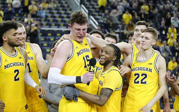 Jon Teske (15), Zavier Simpson (3), and Michigan Team