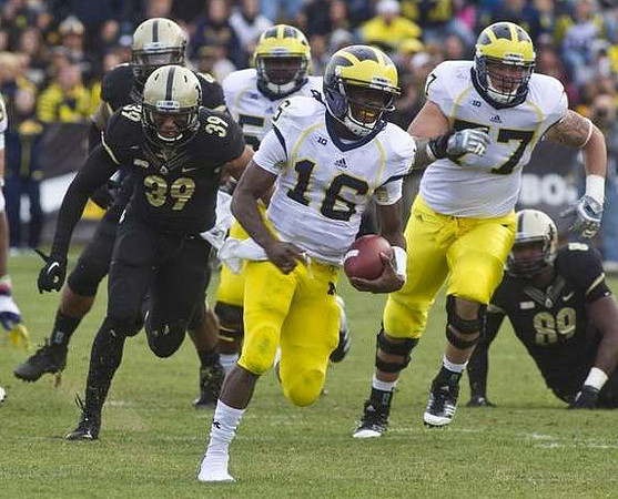Denard Robinson (16), Ricky Barnum (52), and Taylor Lewan (77)