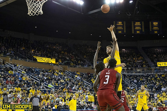 Hunter Dickinson (1), Phil Martelli, and DeVante' Jones (12)