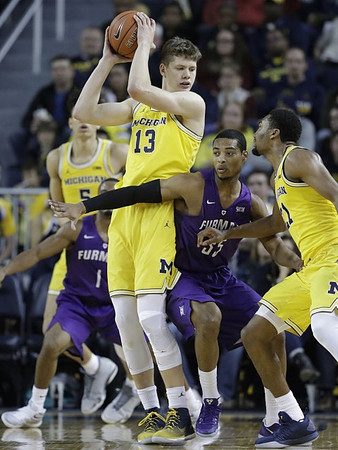 Moritz Wagner (13), Zak Irvin (21), and D.J. Wilson (5)