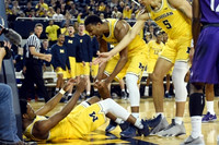 Derrick Walton Jr. (10), Zak Irvin (21), and D.J. Wilson (5)