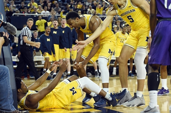 Derrick Walton Jr. (10), Zak Irvin (21), and D.J. Wilson (5)