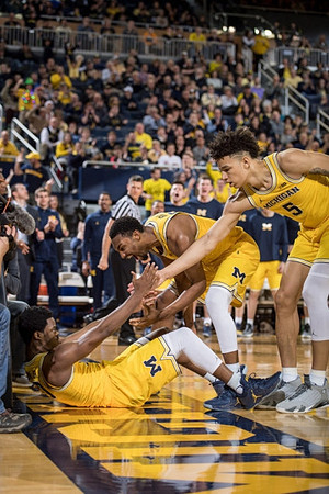 Derrick Walton Jr. (10), Zak Irvin (21), and D.J. Wilson (5)