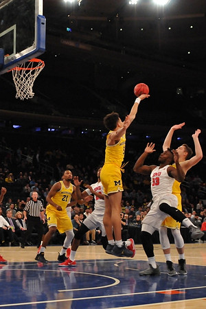 Zak Irvin (21), D.J. Wilson (5), and Mark Donnal (34)