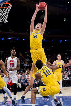 Mark Donnal (34), Derrick Walton Jr. (10), and Duncan Robinson (22)