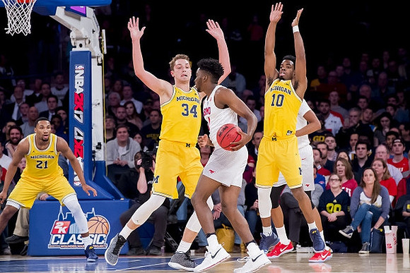 Zak Irvin (21), Mark Donnal (34), and Derrick Walton Jr. (10)