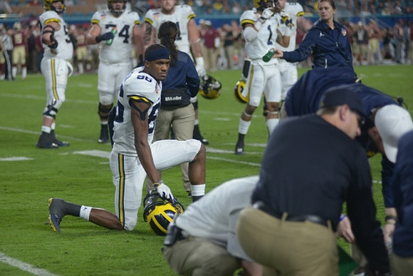 Jake Butt (88), Jim Harbaugh, Jehu Chesson (86), and Michigan Team