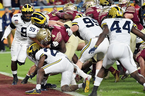 Mike McCray (9), Noah Furbush (59), Jourdan Lewis (26), Matthew Godin (99), and Delano Hill (44)