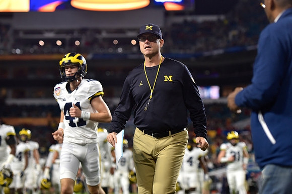 Jacob West (41) and Jim Harbaugh