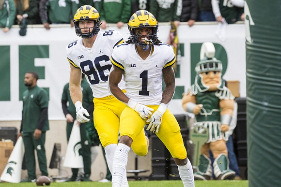 Luke Schoonmaker (86), Andrel Anthony (1), and Michigan State Mascot