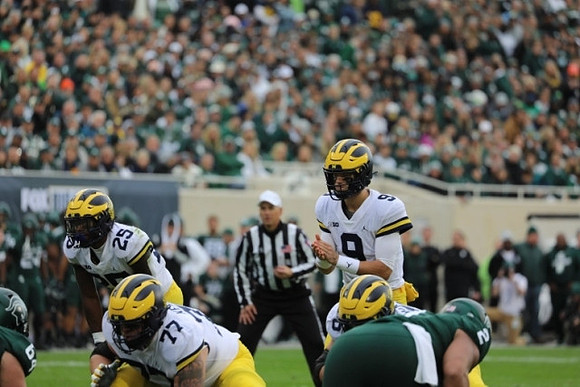 Hassan Haskins (25), Trevor Keegan (77), and J.J. McCarthy (9)