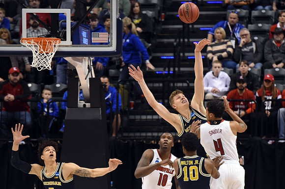 D.J. Wilson (5), Moritz Wagner (13), and Derrick Walton Jr. (10)