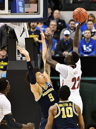 D.J. Wilson (5) and Derrick Walton Jr. (10)