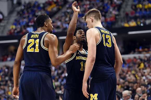 Zak Irvin (21), Derrick Walton Jr. (10), and Moritz Wagner (13)