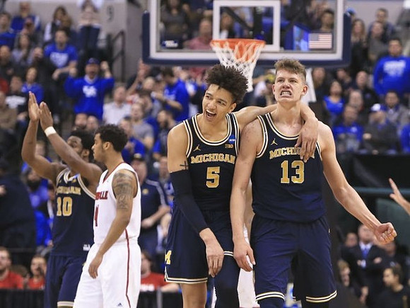 Derrick Walton Jr. (10), D.J. Wilson (5), and Moritz Wagner (13)