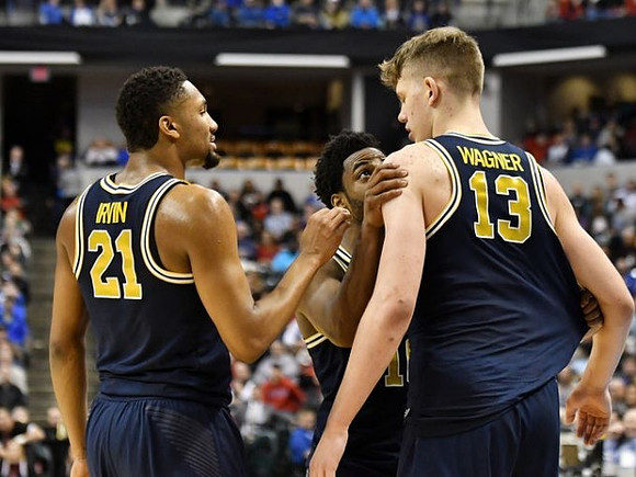 Zak Irvin (21), Derrick Walton Jr. (10), and Moritz Wagner (13)