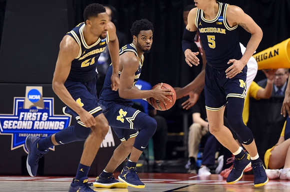 Zak Irvin (21), Derrick Walton Jr. (10), and D.J. Wilson (5)