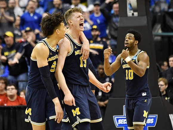 D.J. Wilson (5), Moritz Wagner (13), and Derrick Walton Jr. (10)