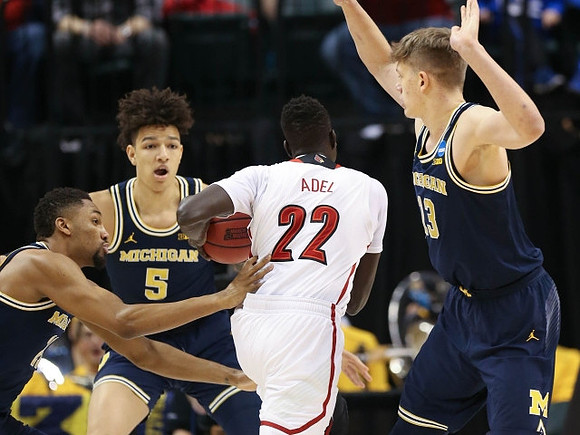 Zak Irvin (21), D.J. Wilson (5), and Moritz Wagner (13)