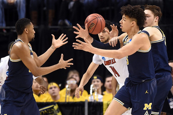Zak Irvin (21), D.J. Wilson (5), and Mark Donnal (34)