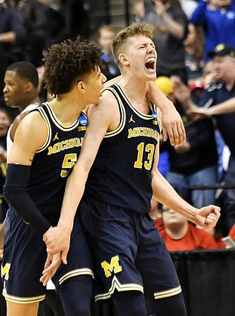 D.J. Wilson (5) and Moritz Wagner (13)
