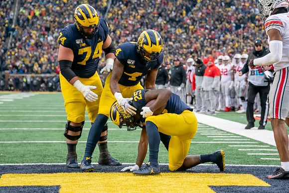 Ben Bredeson (74), Nico Collins (4), and Hassan Haskins (25)