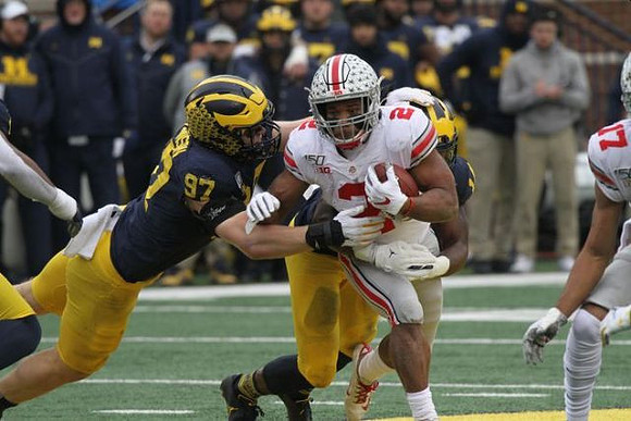 Aidan Hutchinson (97) and Josh Metellus (14)