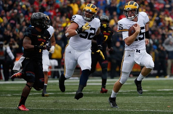Mason Cole (52) and Jake Rudock (15)