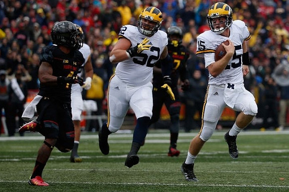 Mason Cole (52) and Jake Rudock (15)
