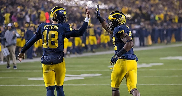 Brandon Peters (18) and Karan Higdon (22)