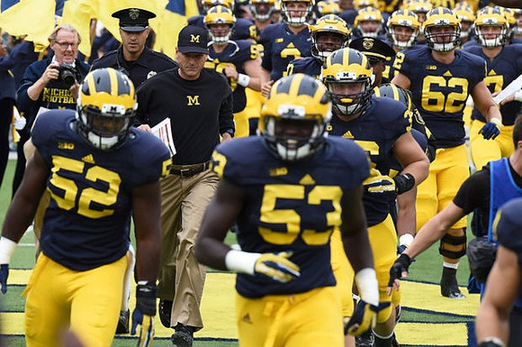 Mason Cole (52), Jim Harbaugh, Mario Ojemudia (53), and Blake Bars (62)