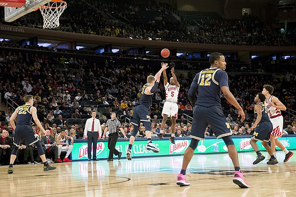 Duncan Robinson (22), Moritz Wagner (13), Muhammad-Ali Abdur-Rahkman (12), Zavier Simpson (3), and Nebraska Head Coach Tim Miles
