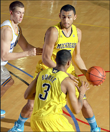 Trey Burke (3) and Jon Horford (15)