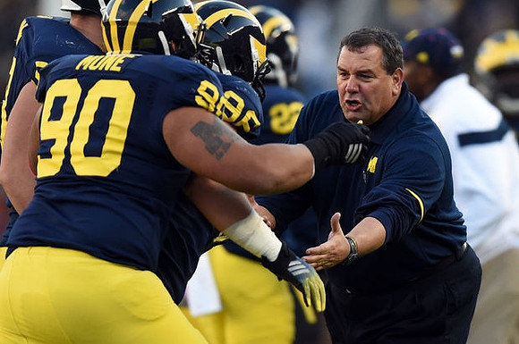 Bryan Mone (90) and Brady Hoke