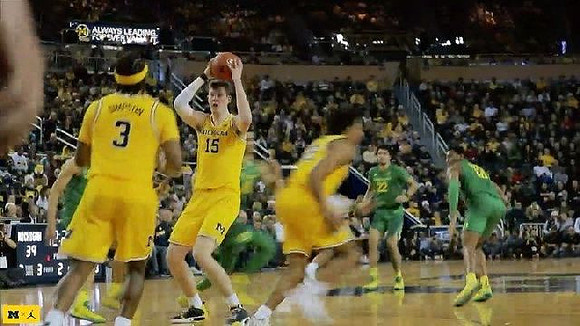 Zavier Simpson (3), Jon Teske (15), and Eli Brooks (55)