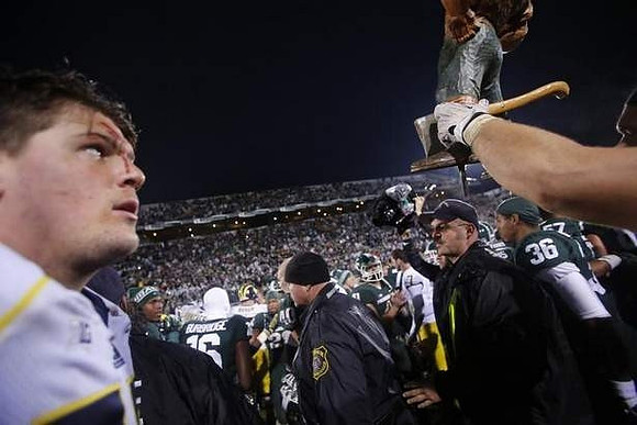 Taylor Lewan (77) and Paul Bunyan Trophy