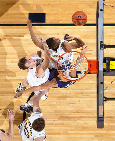 Evan Smotrycz (23), Zack Novak (0), and Trey Burke (3)